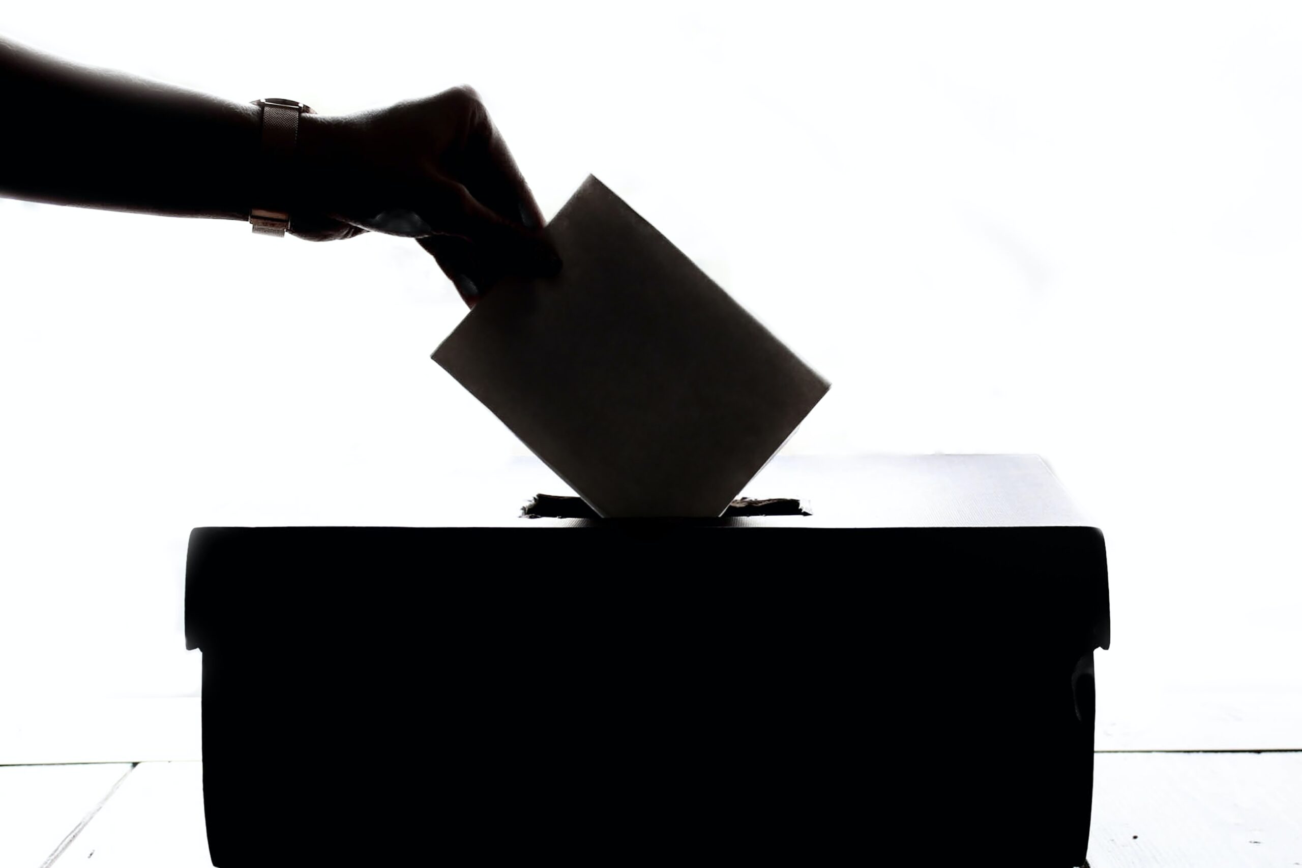 An hand putting a paper inside a ballot box