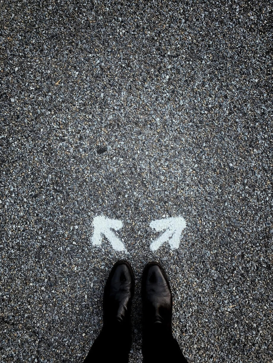 Two white arrow signs in front of a boot