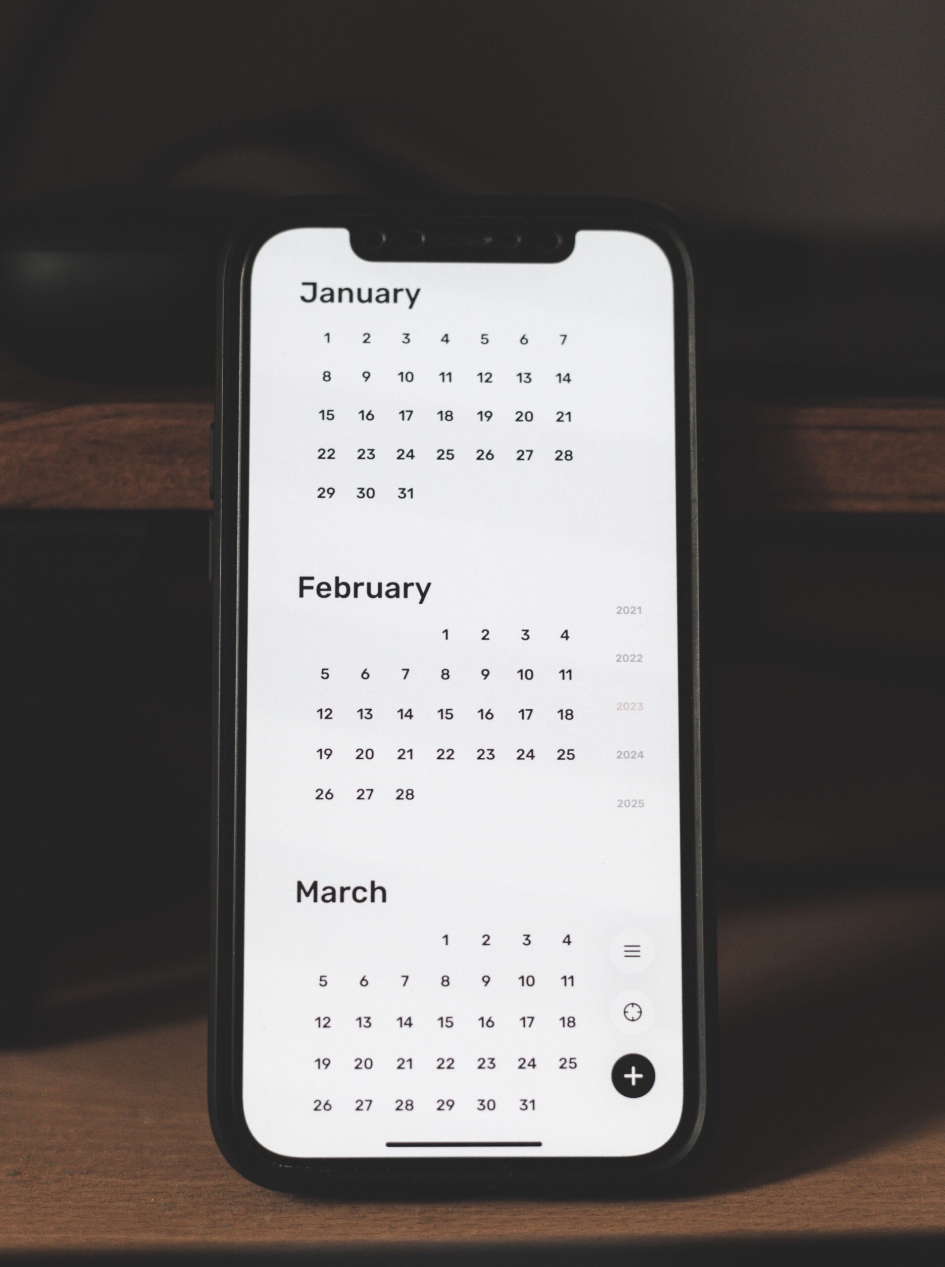 A calendar shows three months on the display of a phone.
