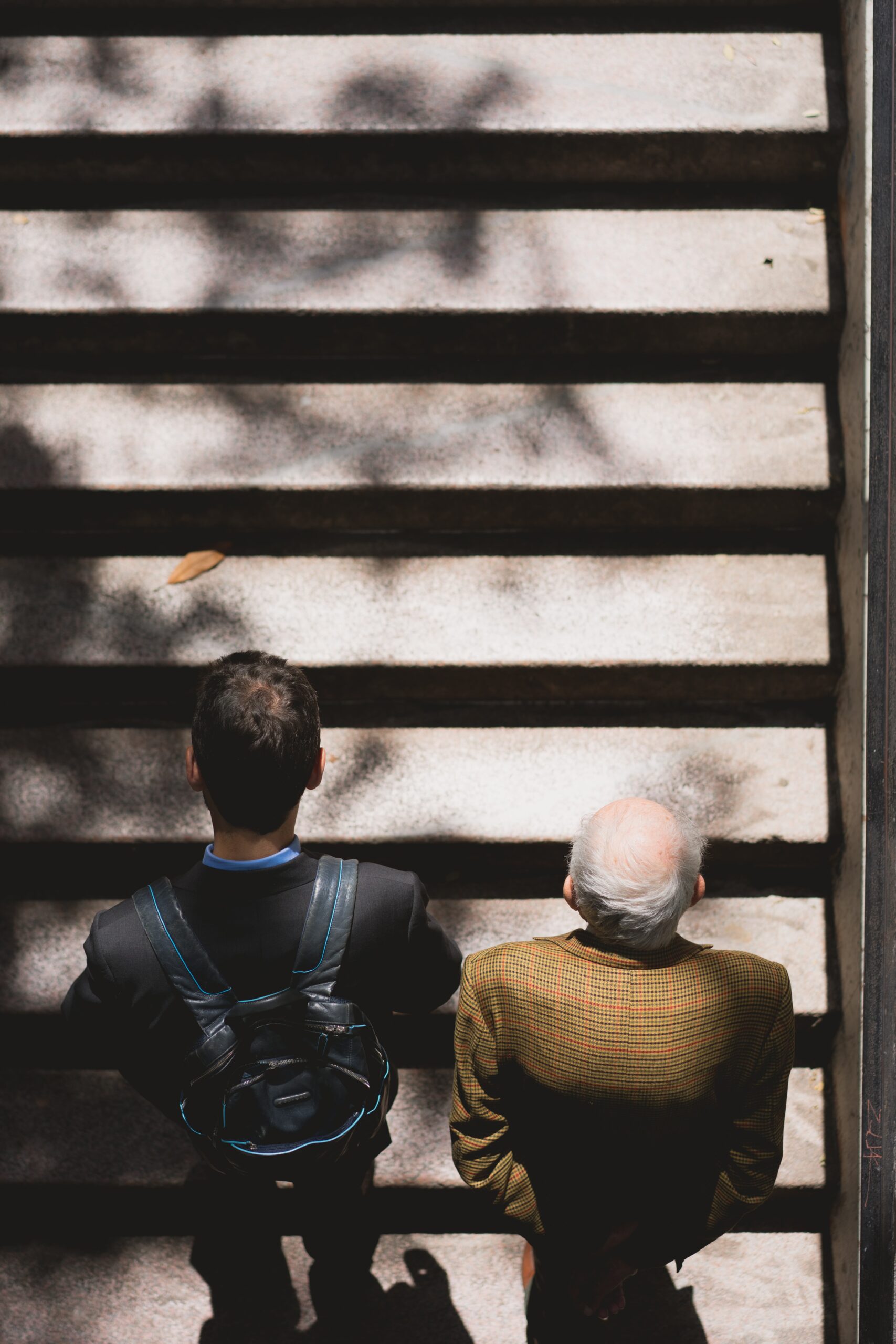 Top view of an old man climbing steps with a young guy