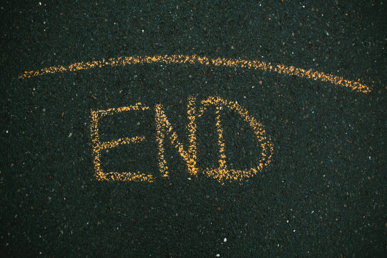 The word end is painted in yellow on a rough surface.