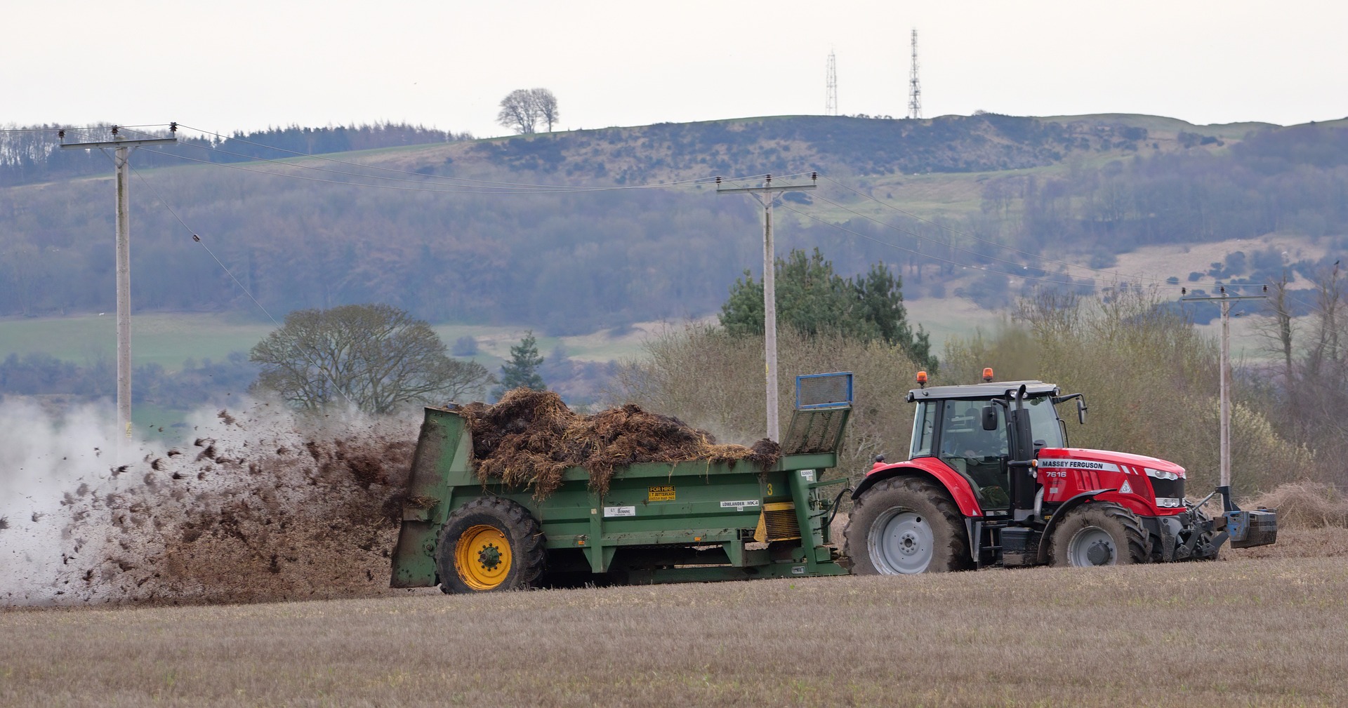 Spreading muck from a tractor into the field